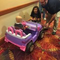 Jennifer Moore, Hudson, and Marcus Fletcher chat with a youngster as he rides in the Aztech 157 remote-controlled car at the Dana Farber Jimmy Fund holiday party where the robotics team were part of the entertainment for the children and families. 