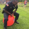 Officer Richardson hippity hops across Finn School's field